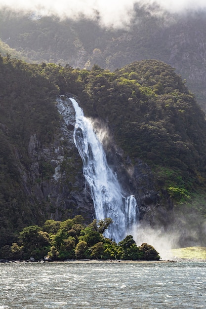 Stromen van de bergenwaterval op de achtergrond van een groene berg in Nieuw-Zeeland