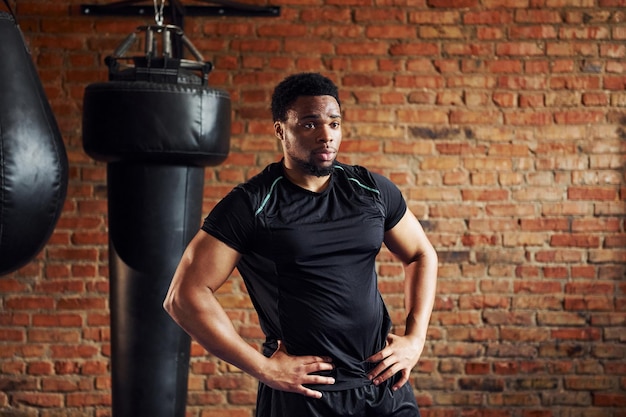 Strong african american man in sportive clothes standing in the gym