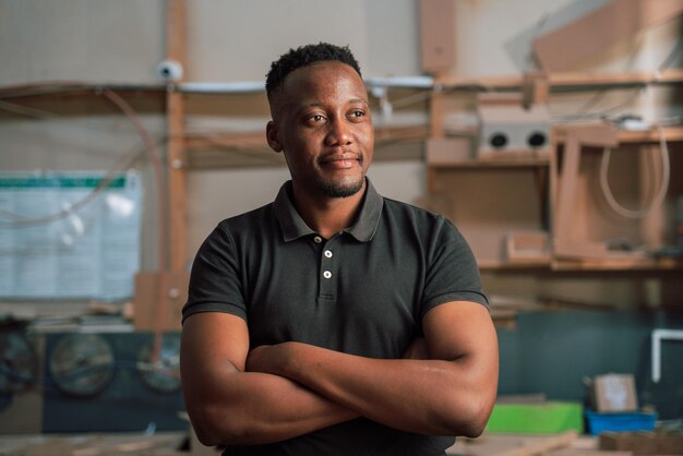 Strong african man smiling in carpentry workshop