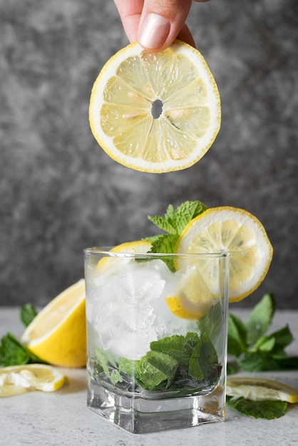 Strong alcoholic beverage in square glass with lemon