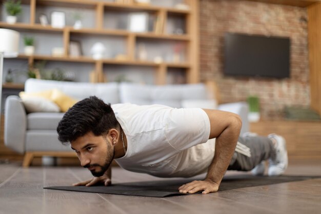 Photo strong arabian man doing plank position on yoga mat