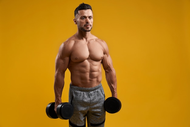 Strong athletic man holding dumbbells