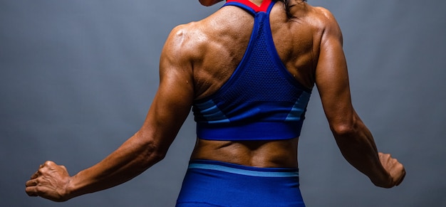 strong bald bodybuilder with six pack. Bodybuilder woman with perfect abs, shoulders,biceps, triceps and chest, personal fitness trainer flexing his muscles.