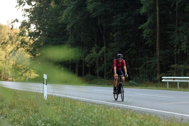 写真 保護ヘルメット鏡のメガネスポーツ服を着て自転車に乗っている強いひげの男