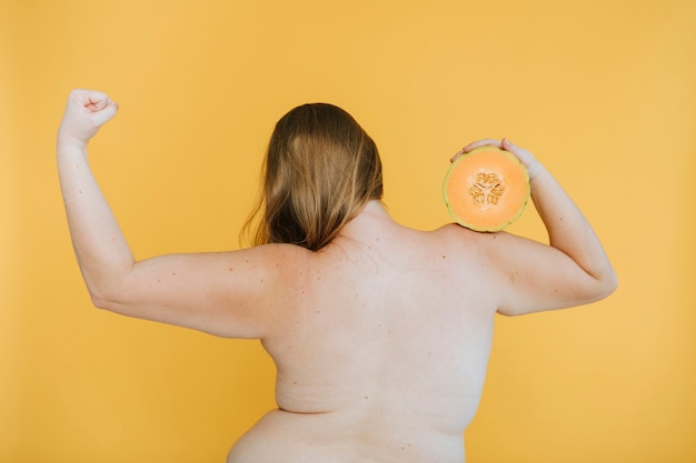 Strong blond woman holding a cantaloupe melon