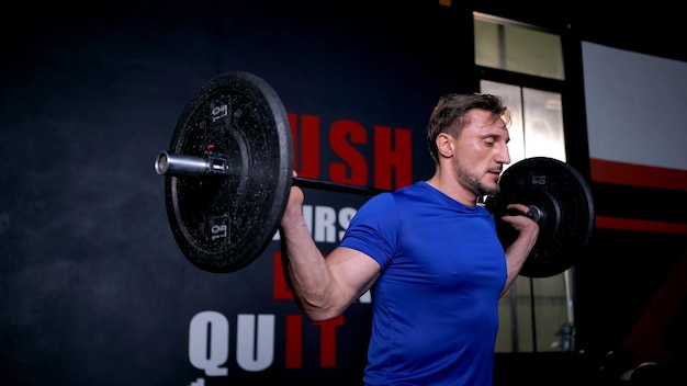 Strong bodybuilder athletic man with weight lifting during workout at fitness. Health and wellbeing lifestyle.