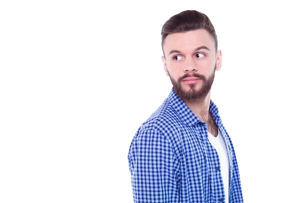 Strong confident handsome and bearded man in casual checkered shirt is posing isolated on white background with copy space for text and advertising