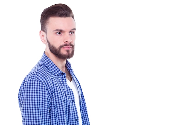 Strong confident handsome and bearded man in casual checkered shirt is posing isolated on white background with copy space for text and advertising