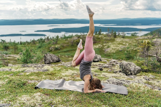 Strong female trainer handstand doing yoga asana exercises balance and harmony of the body