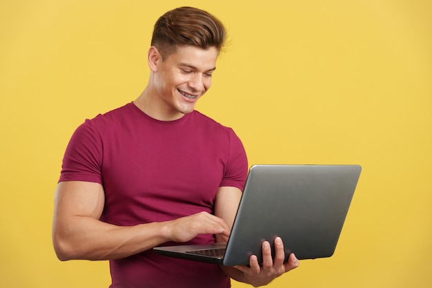 Strong and happy man using a laptop and smiling