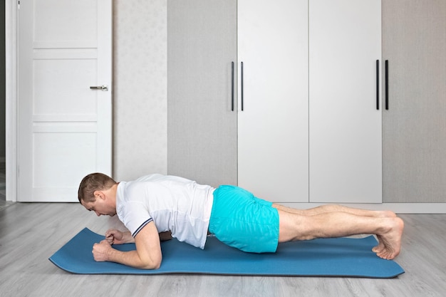 A strong healthy man with muscles training at home fitness at home yoga