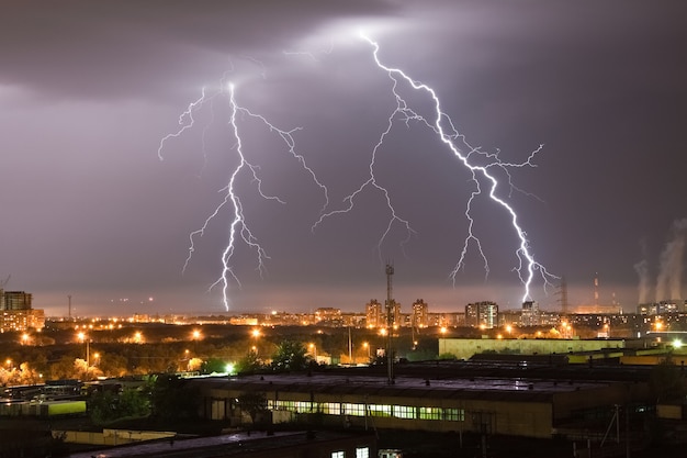 Strong lightning flash in the night sky above the city