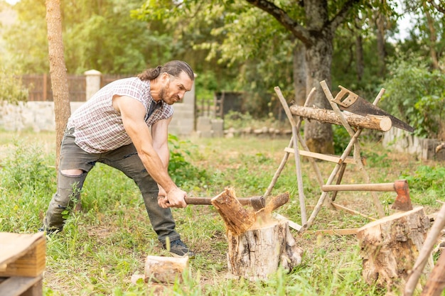 Uomo forte che taglia un ceppo su un giardino