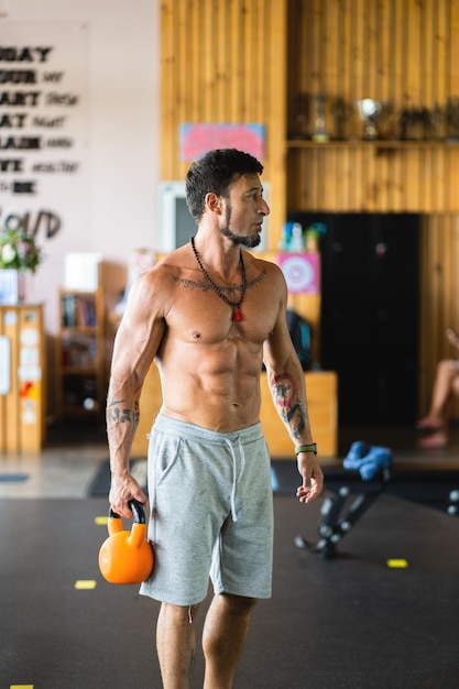 Strong man in the gym holding a kettlebell