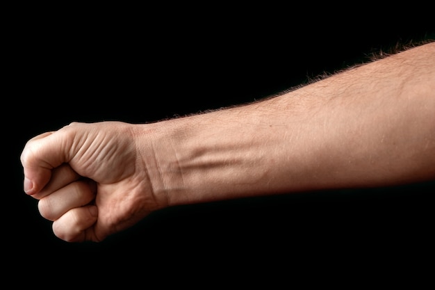 strong man raised his fist on black 