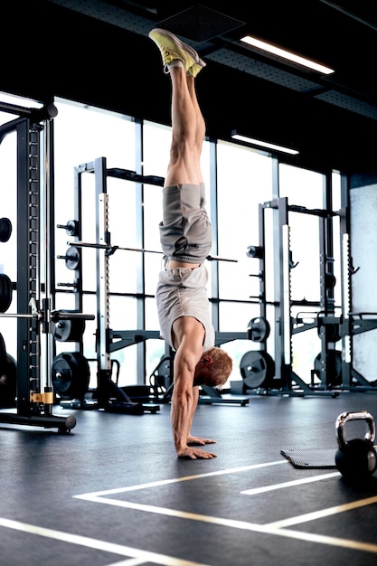 Strong man walking on hand during crossfit training in fitness club