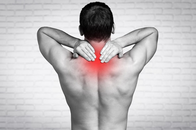 Strong man with neck pain, back view