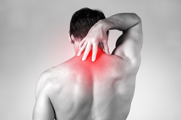 Strong man with neck pain, back view