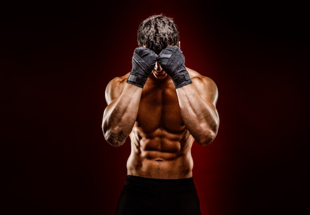 Photo strong muscular fighter hiding face from camera