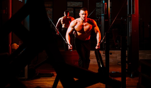 Strong muscular man works out pushing up excercise in gym exercises at triceps Workout lifestyle concept Handsome man doing functional training workout