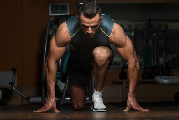 Strong Muscular Men Kneeling On The Floor  Almost Like Sprinter Starting Position