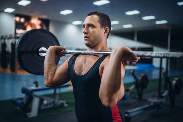 Strong powerlifter doing deadlift a barbell in gym