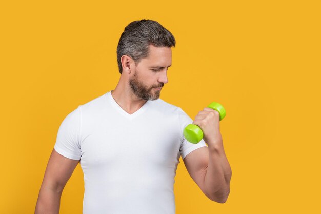 Strong sport man holding dumbbell strong sport man training with dumbbell isolated on yellow