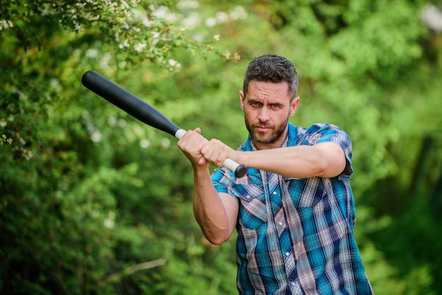 Photo strong temper principle concept confident in his strength bully guy in nature with cudgel wild energy power and strength feel my strength man unshaven strict face hold black baseball bat