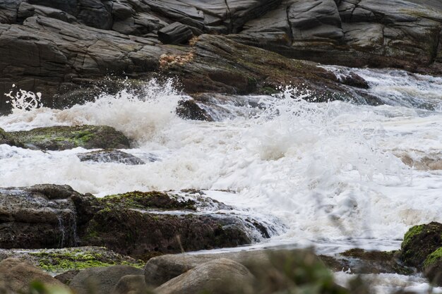 Strong waves crashing on the rocks of Rio das Ostras beach in Rio de Janeiro.