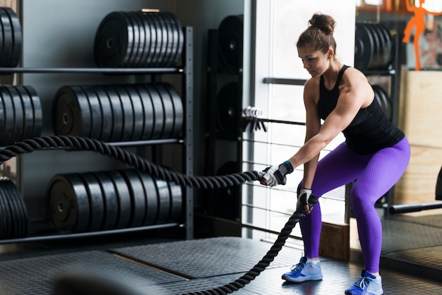 Photo strong woman exercising with ropes