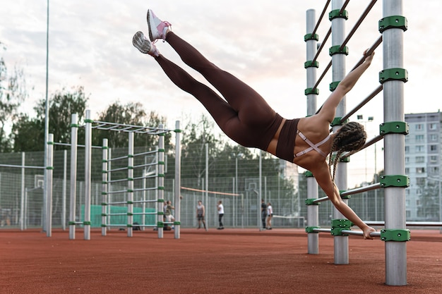 Сильная женщина делает упражнение с человеческим флагом во время художественной гимнастики