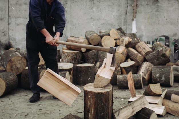 Strong woodcutter chopping wood with a sharp ax