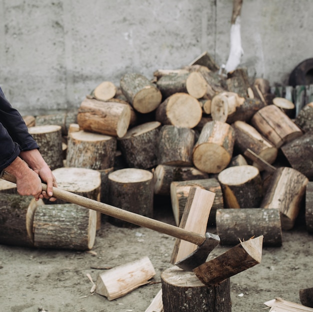 Strong woodcutter chopping wood with a sharp ax