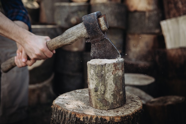 Strong woodcutter chopping wood with a sharp ax