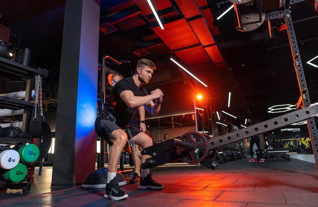 Forte giovane uomo duro allenamento in palestra sportivo muscolare atletico che fa esercizio