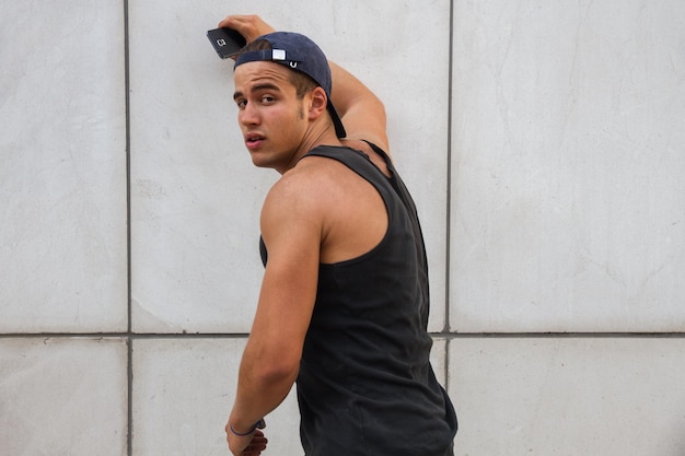 Strong young man with mobile phone in the street