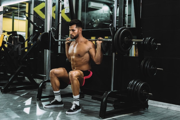 Strongman squatting with weights in a gym