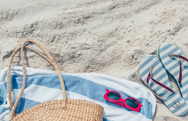 Strozak, zonnebril en slippers op een tropisch zandstrand