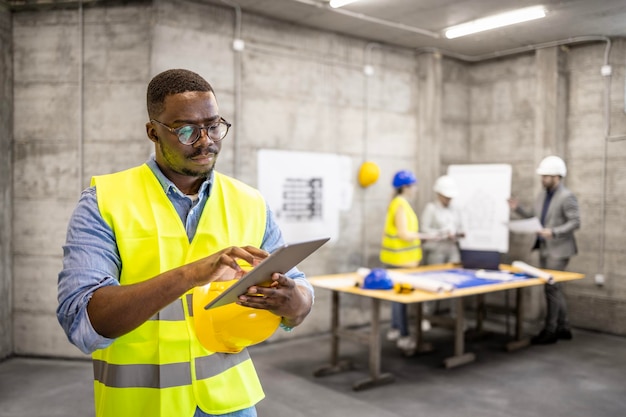 Structural engineer working on digital tablet at construction site