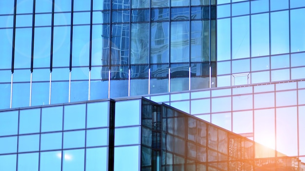 Structural glass wall reflecting blue sky Abstract modern architecture fragment Glass building