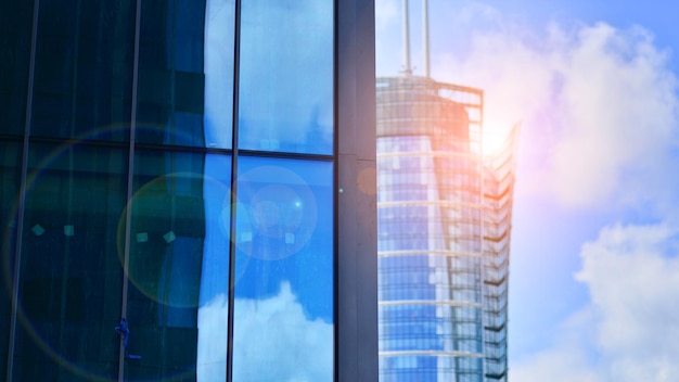 Structural glass wall reflecting blue sky Abstract modern architecture fragment