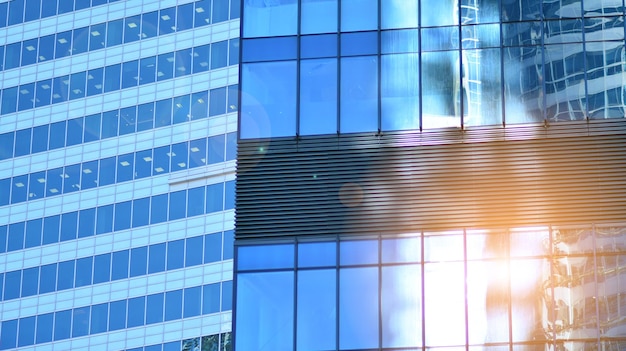 Structural glass wall reflecting blue sky Abstract modern architecture fragment