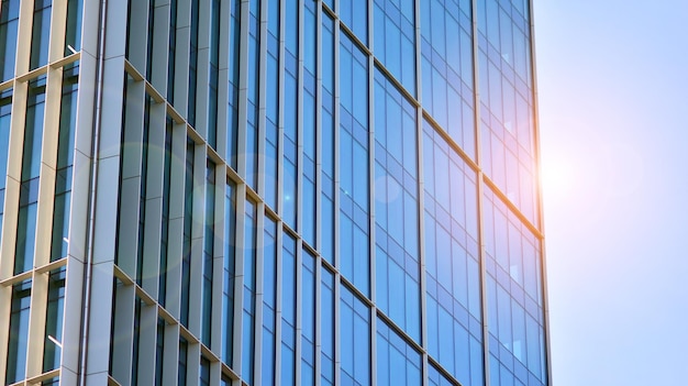 Structural glass wall reflecting blue sky Abstract modern architecture fragment