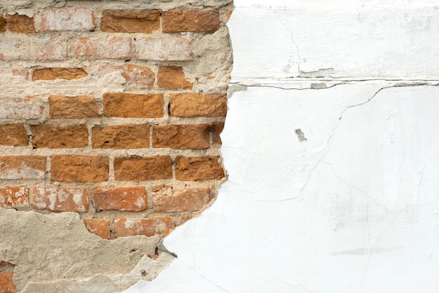 깨진 석고와 치장 벽토가 있는 구조 박리 석고 그런 지 배경이 있는 오래된 벽돌 벽