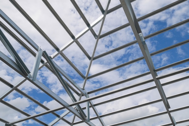 Structuur van stalen dakframe met blauwe lucht en wolken