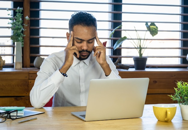 Struggling with occupational stress Shot of a young businessman experiencing stress during a late night at work