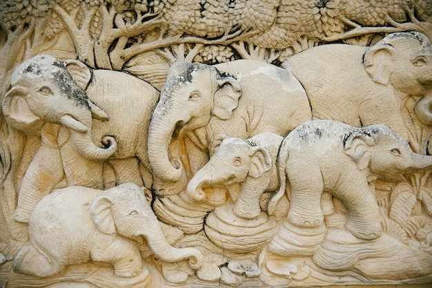 stucco on the facade of the house the image of a family of elephants