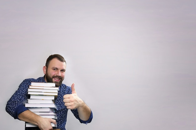 Student adult beard man with stack of book isolated on a grey background