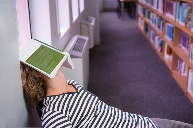 Фото Студент спал в библиотеке с книгой на лице