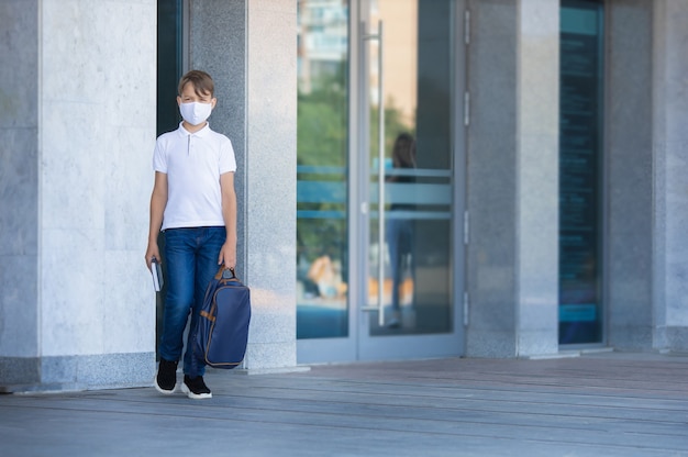 Student boy is leaving school alone during covid 19 pandemic